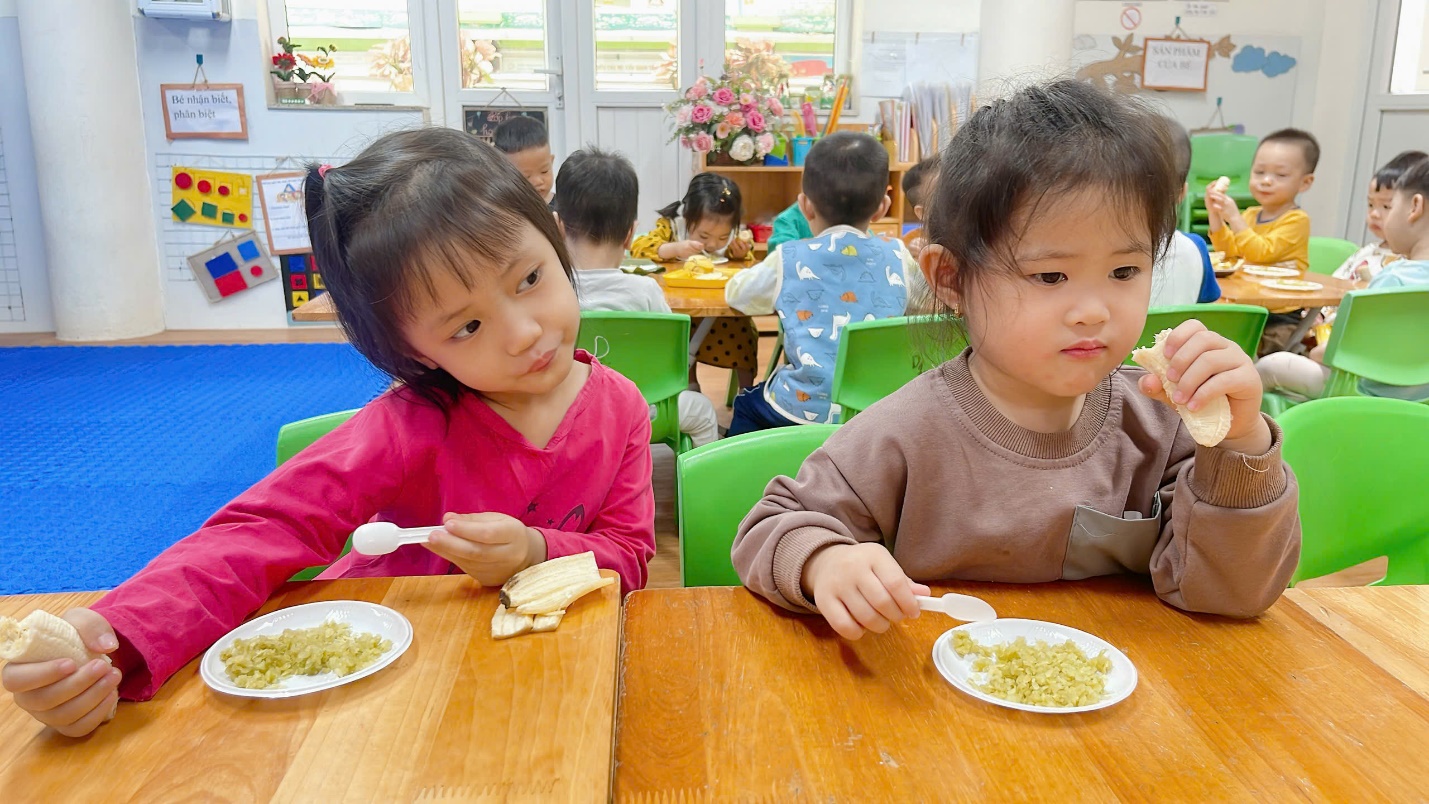 A group of children eating at a table

Description automatically generated