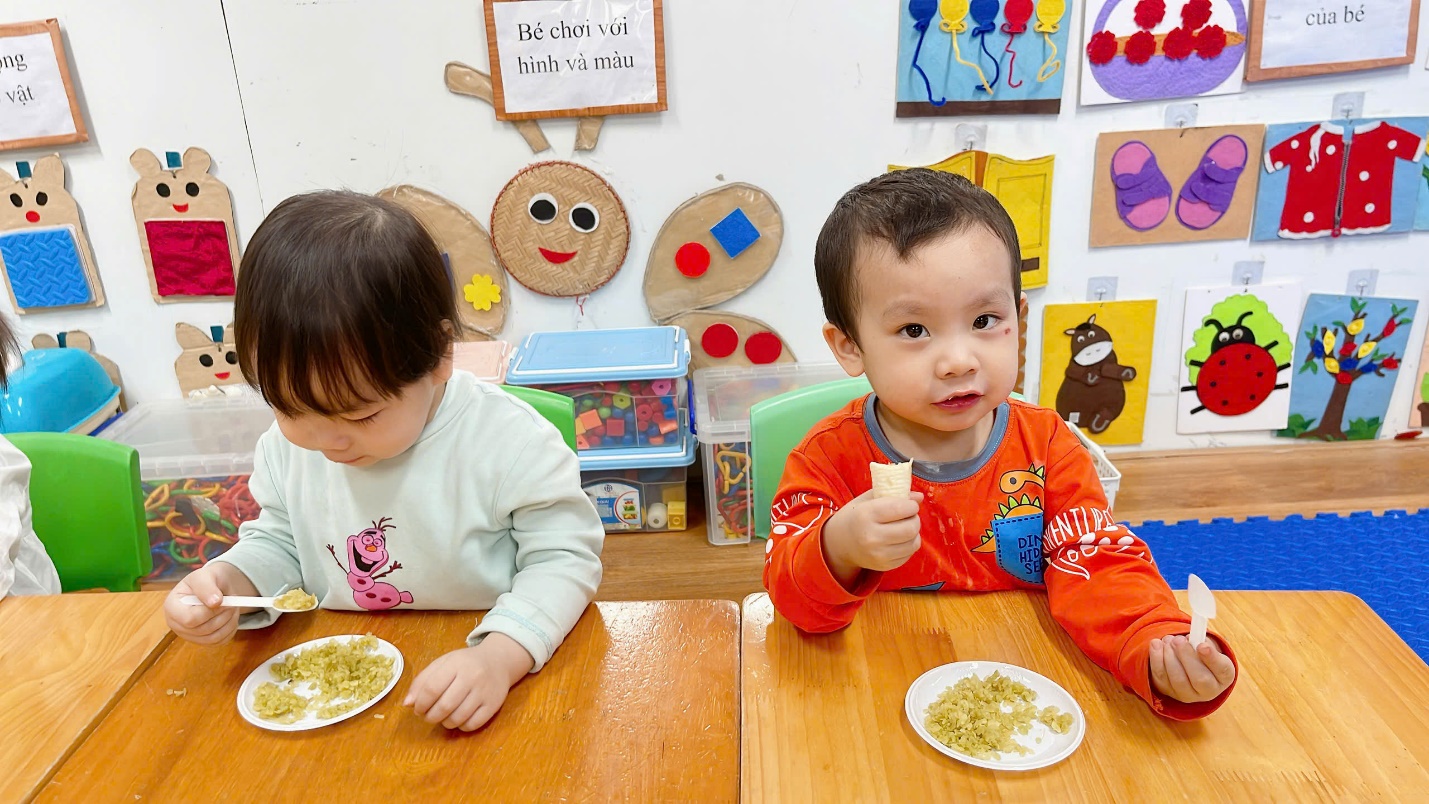 A group of children sitting at a table eating

Description automatically generated