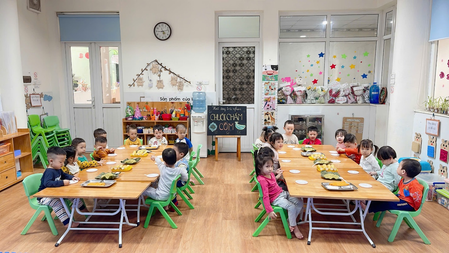 A group of children sitting at tables in a classroom

Description automatically generated