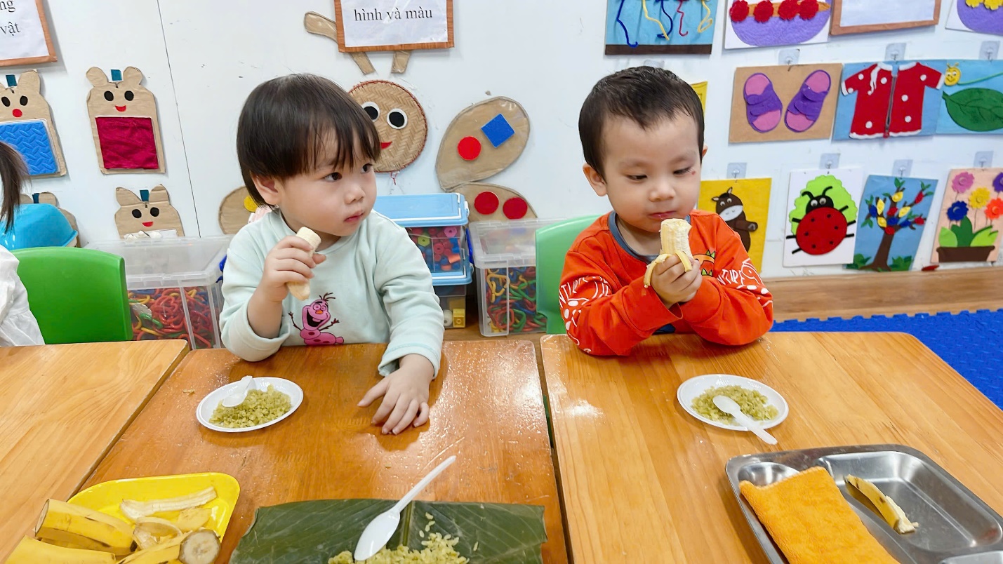 Two children eating at a table

Description automatically generated