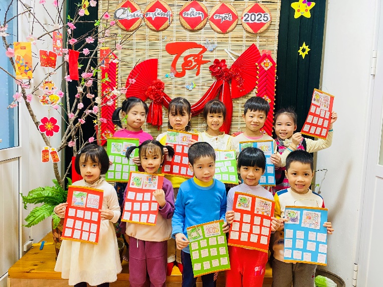 A group of children holding up paper with red and green paper

Description automatically generated