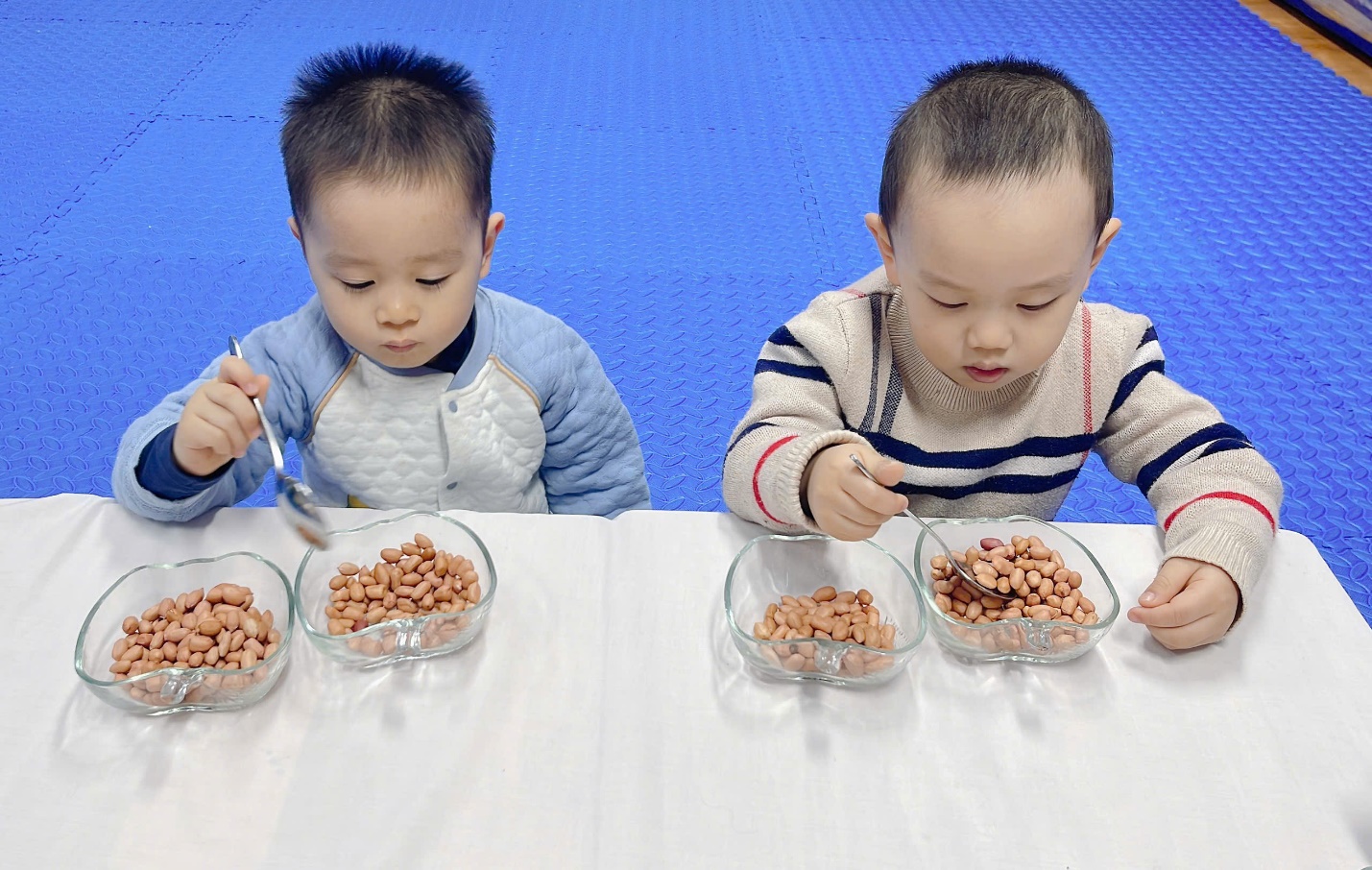 A couple of young boys eating peanuts

Description automatically generated