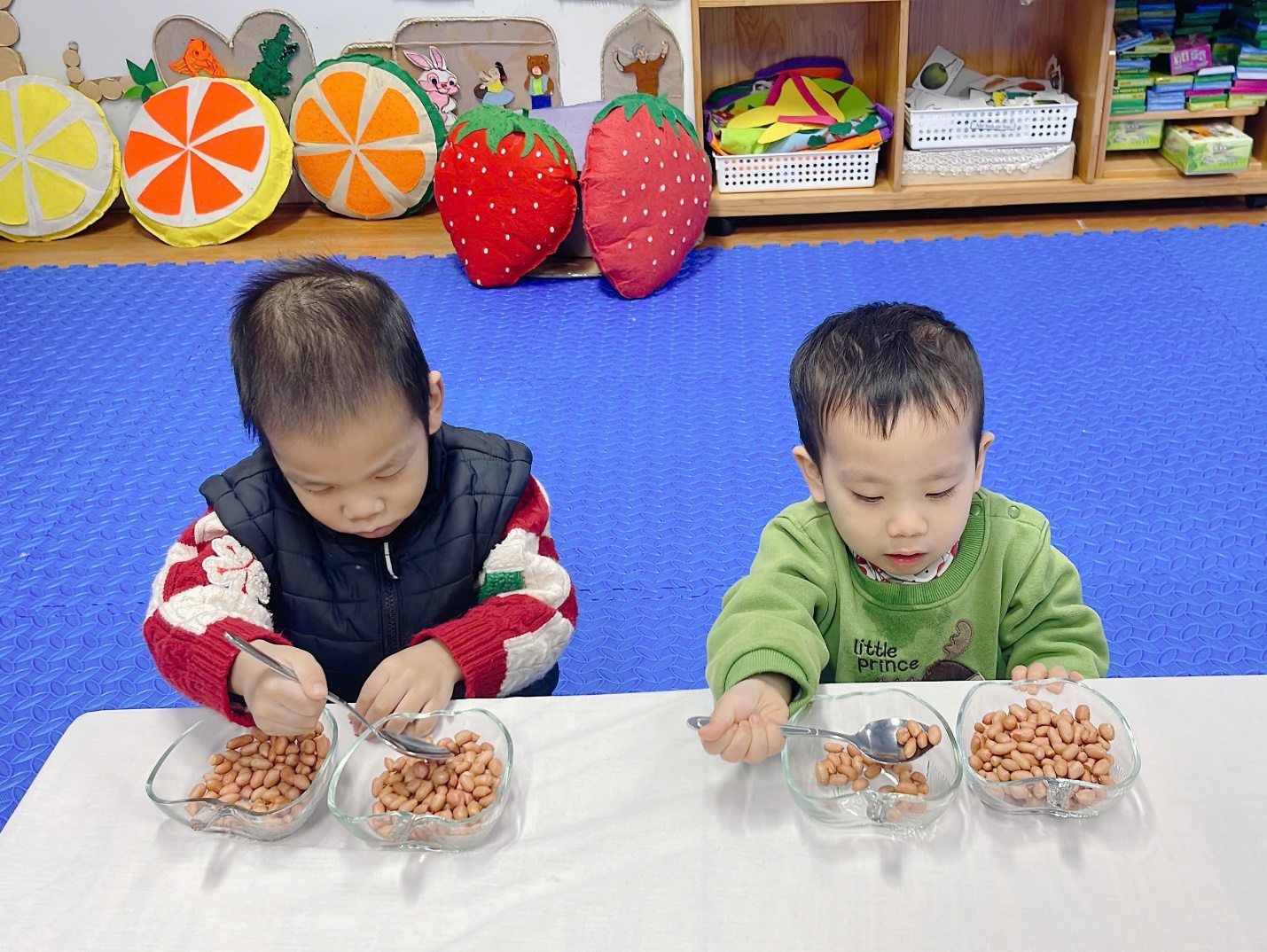 A couple of young boys sitting at a table with bowls of food

Description automatically generated