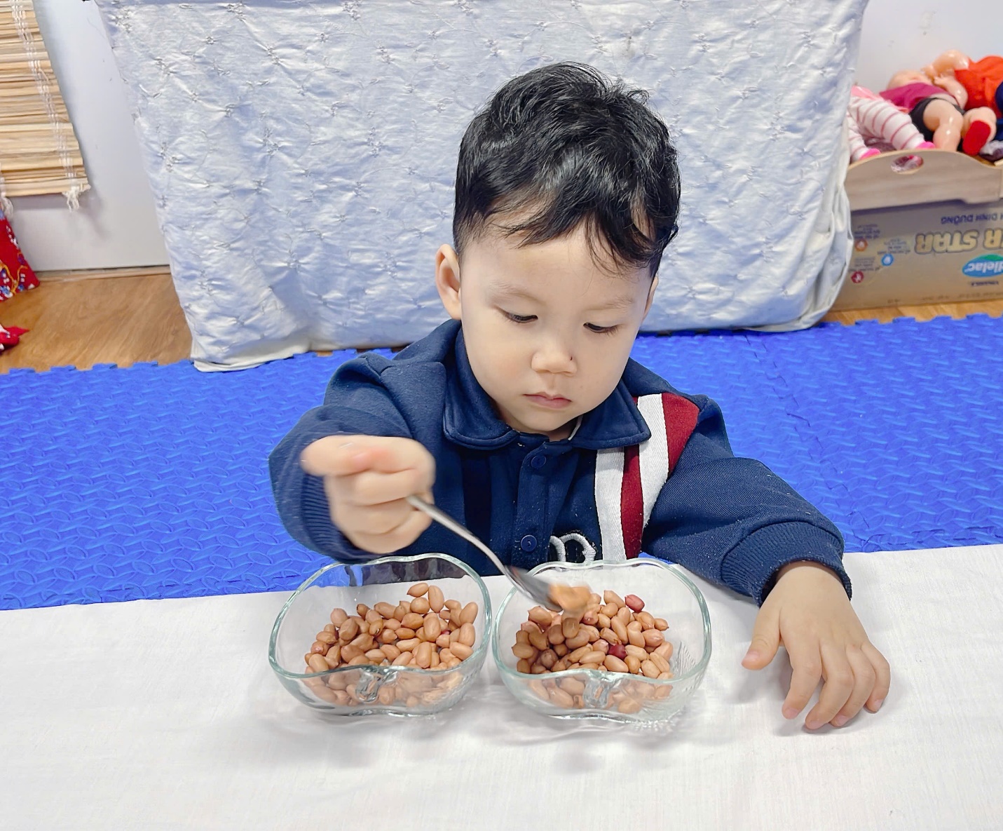A child eating beans with a spoon

Description automatically generated