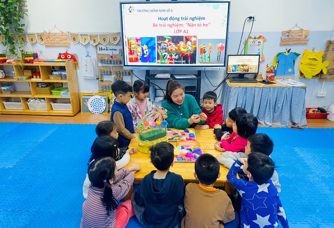 A group of children sitting around a table
Description automatically generated