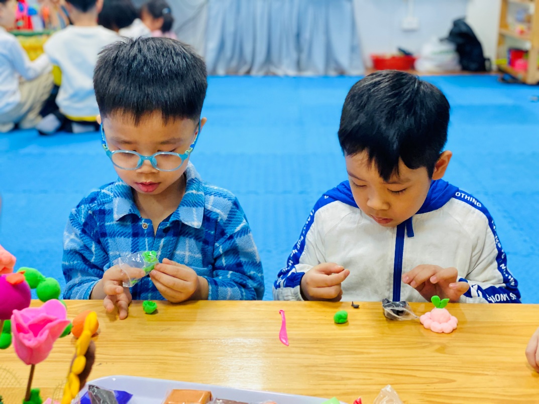 Two boys playing with clay
Description automatically generated
