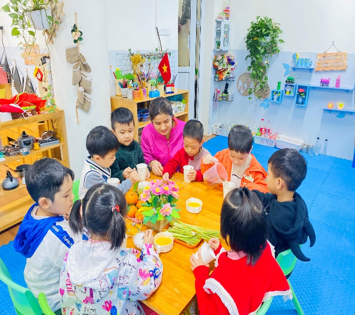 A group of children sitting around a tableDescription automatically generated