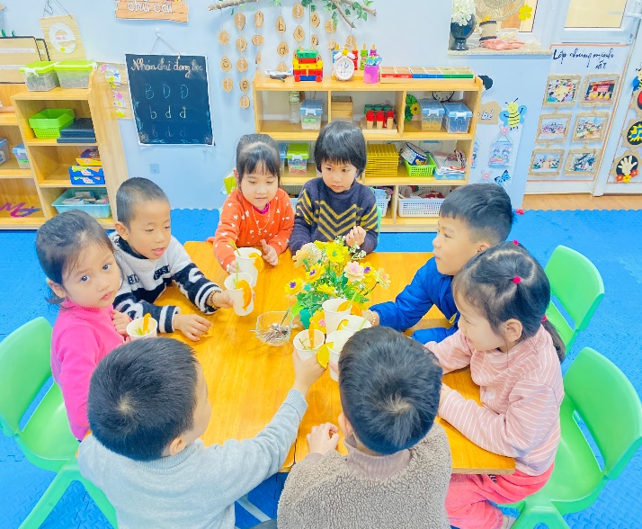 A group of children sitting around a tableDescription automatically generated