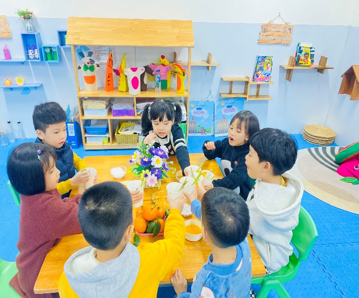 A group of children sitting around a tableDescription automatically generated