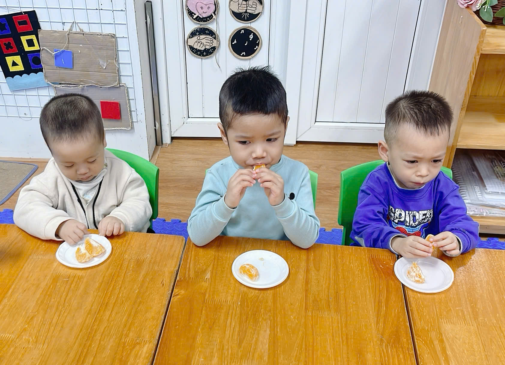 A group of children sitting at a table eating
Description automatically generated