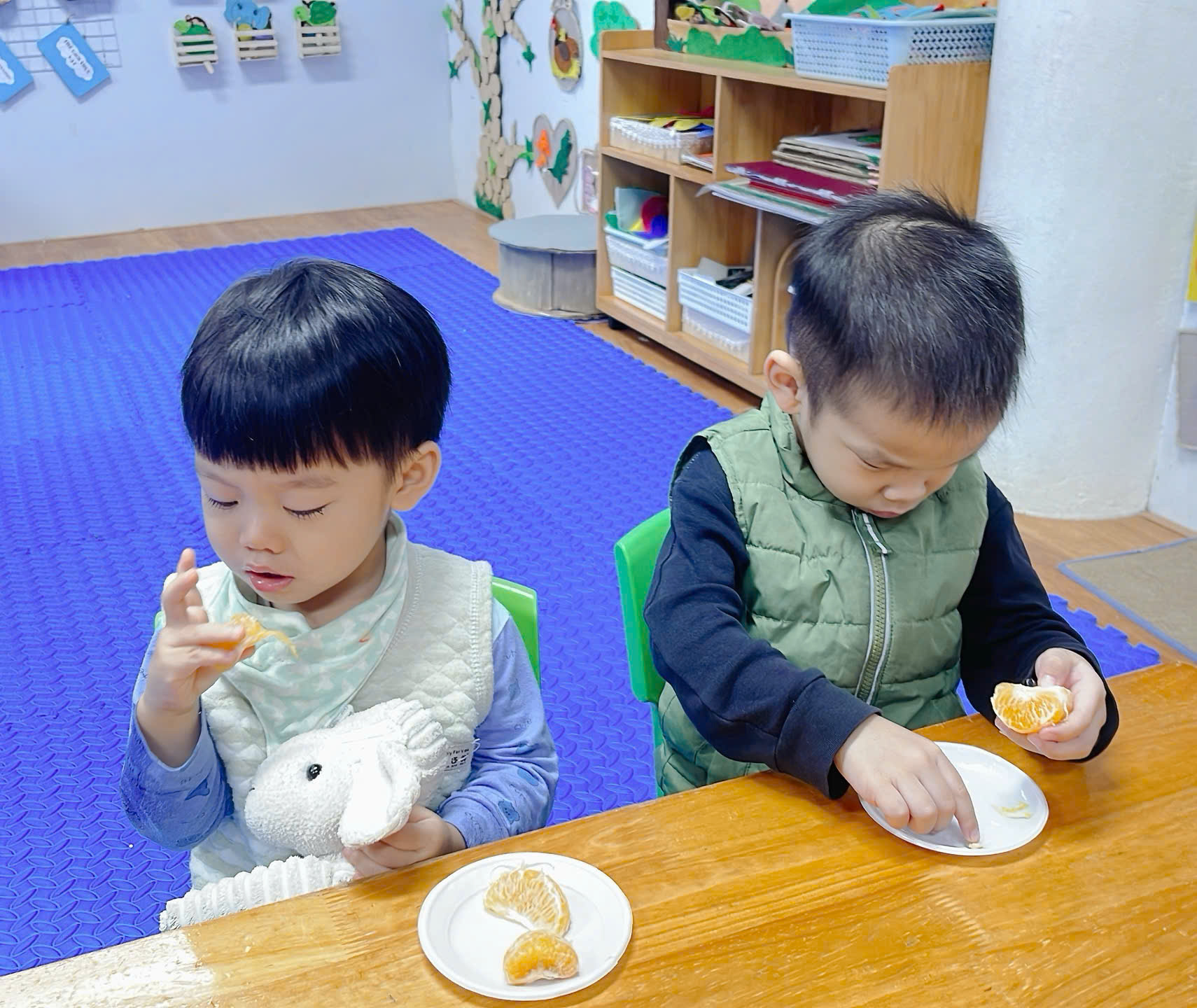 Two children eating at a table
Description automatically generated