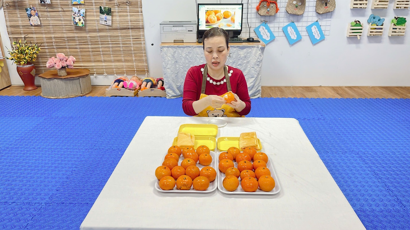 A person sitting at a table with oranges
Description automatically generated