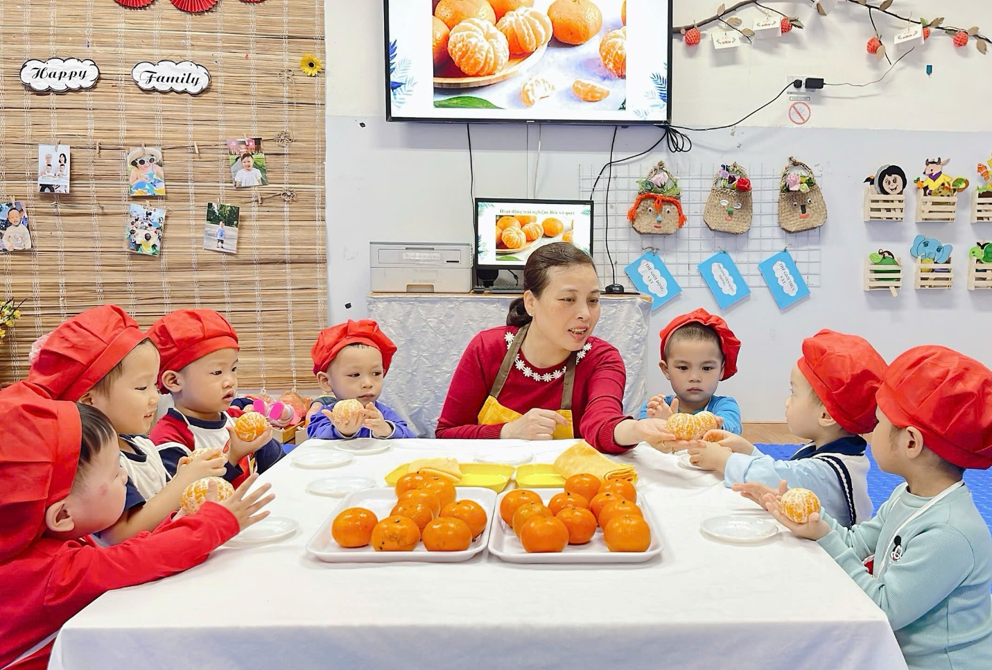 A group of children sitting at a table with food
Description automatically generated