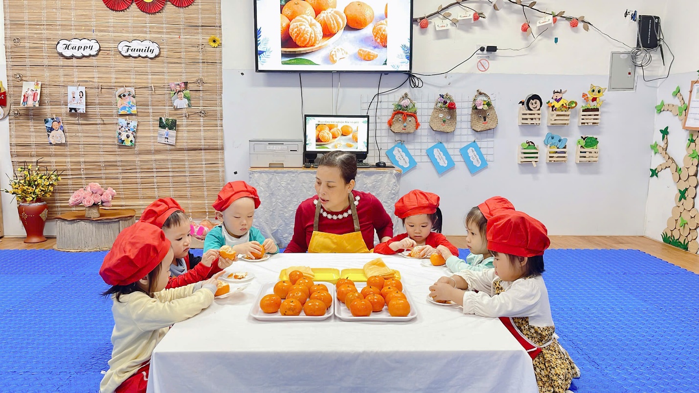 A group of children sitting at a table with food
Description automatically generated