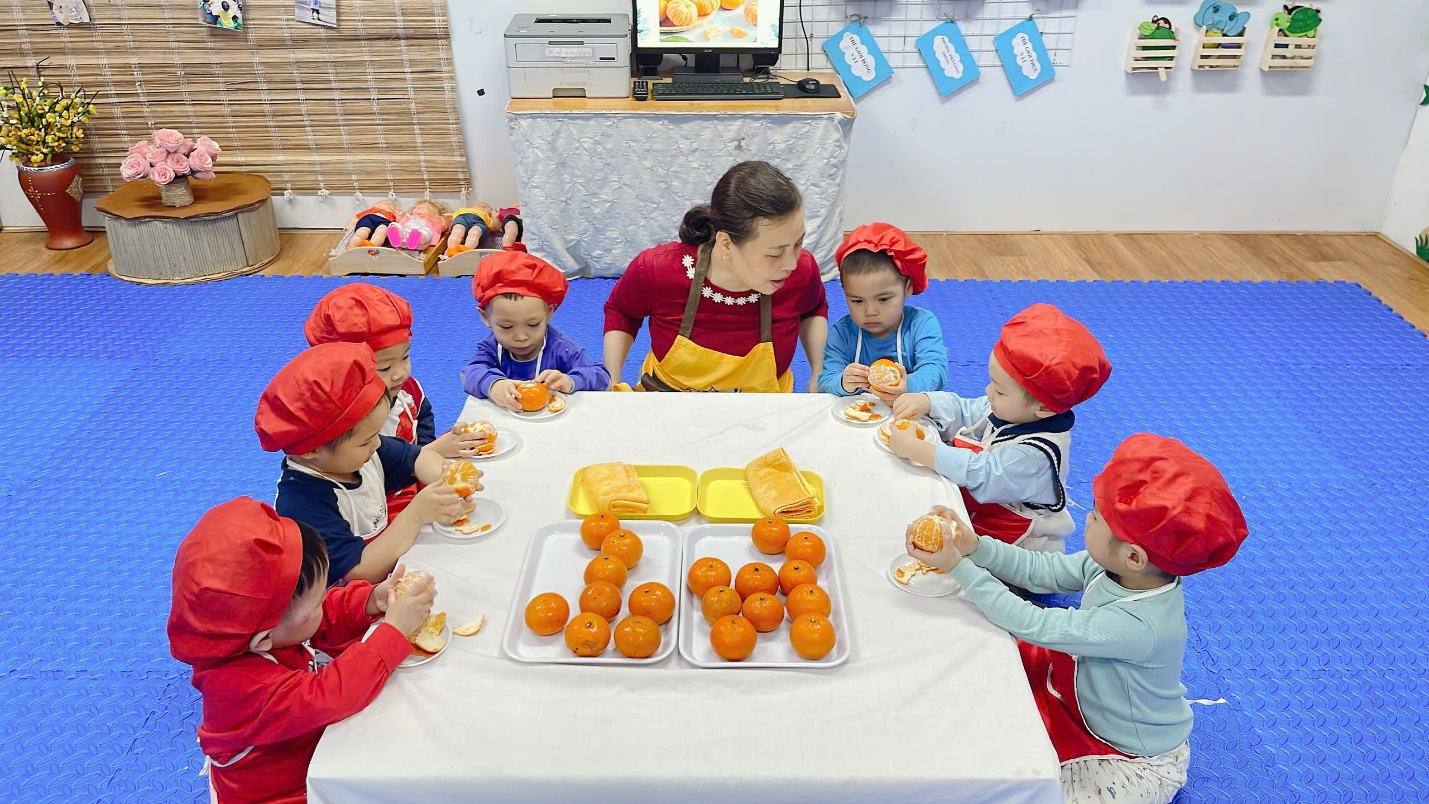 A group of children wearing clothing around a table
Description automatically generated