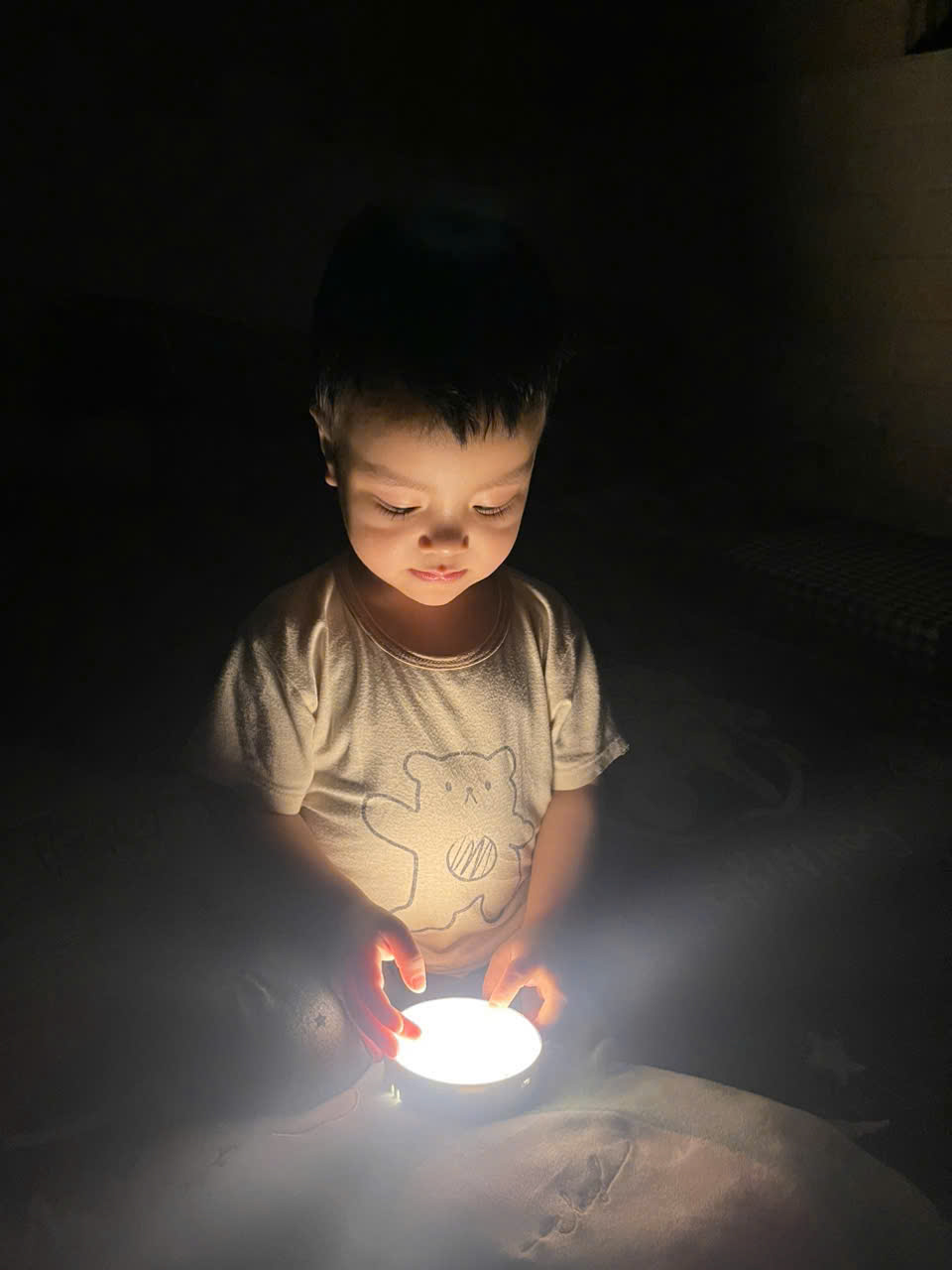 A child holding a light
Description automatically generated