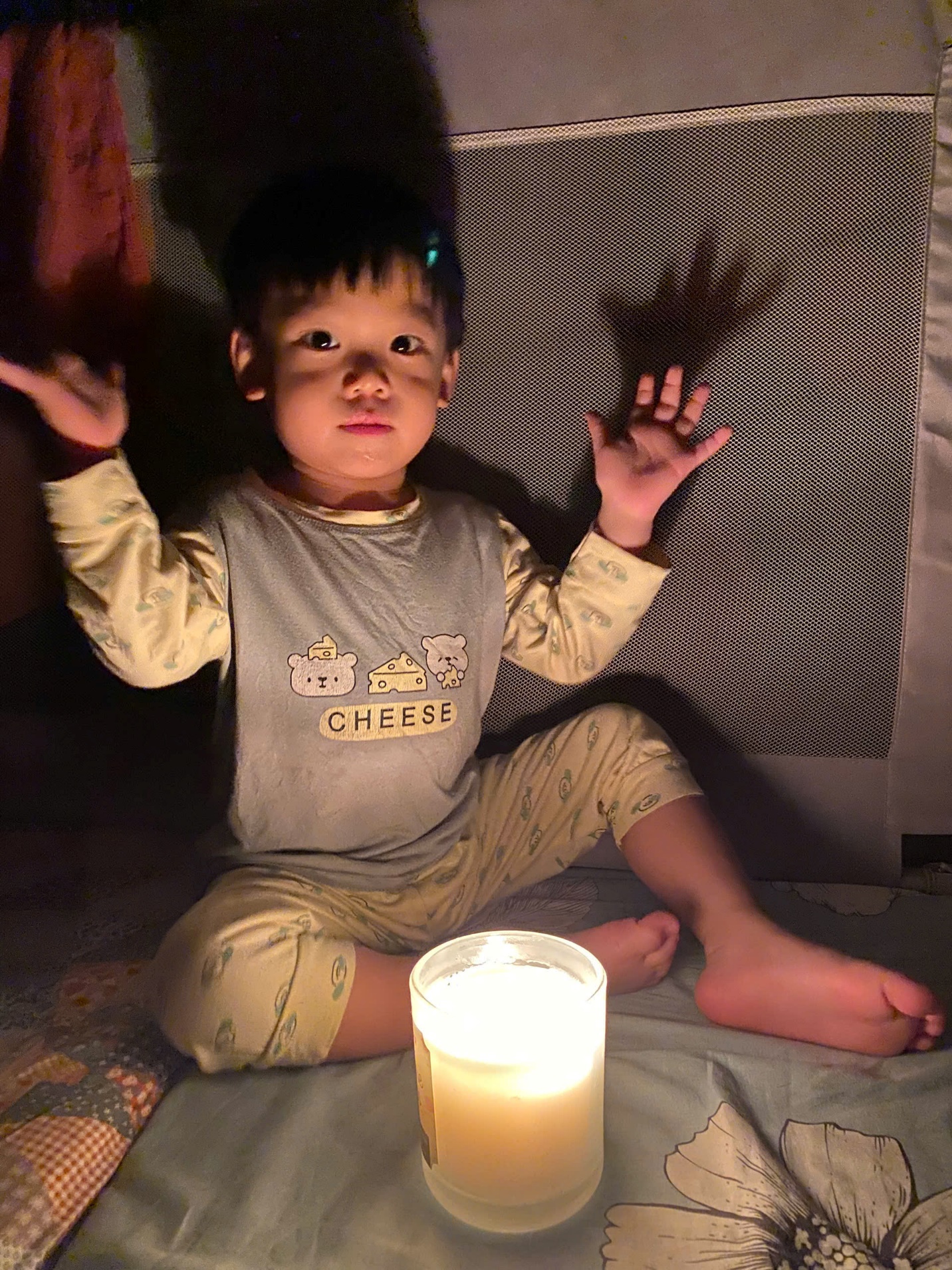 A child sitting on the floor with a candle
Description automatically generated