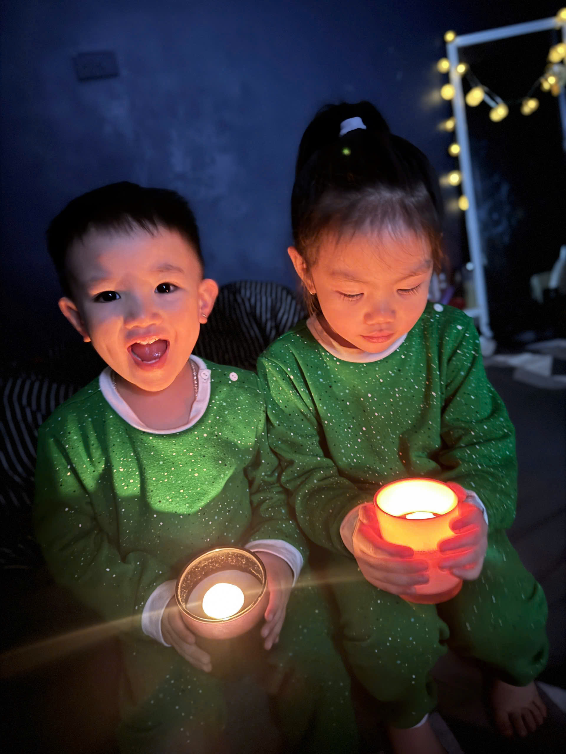 A couple of children holding candles
Description automatically generated