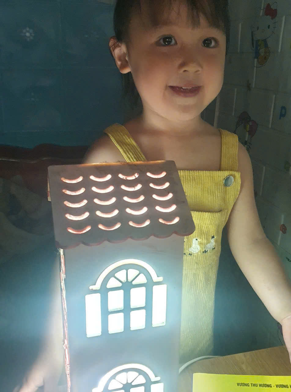 A child holding a small house
Description automatically generated