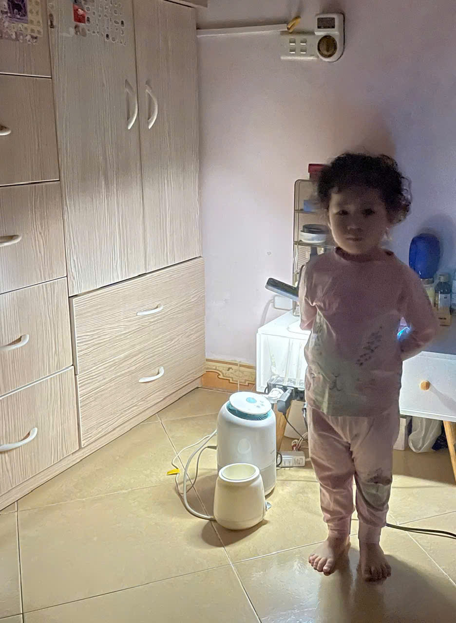 A child standing in a room
Description automatically generated