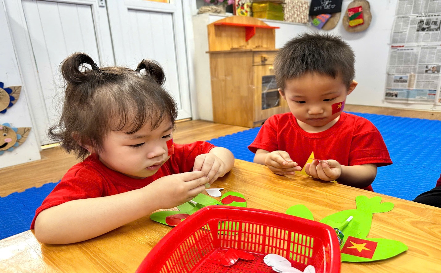 A couple of children sitting at a table
Description automatically generated