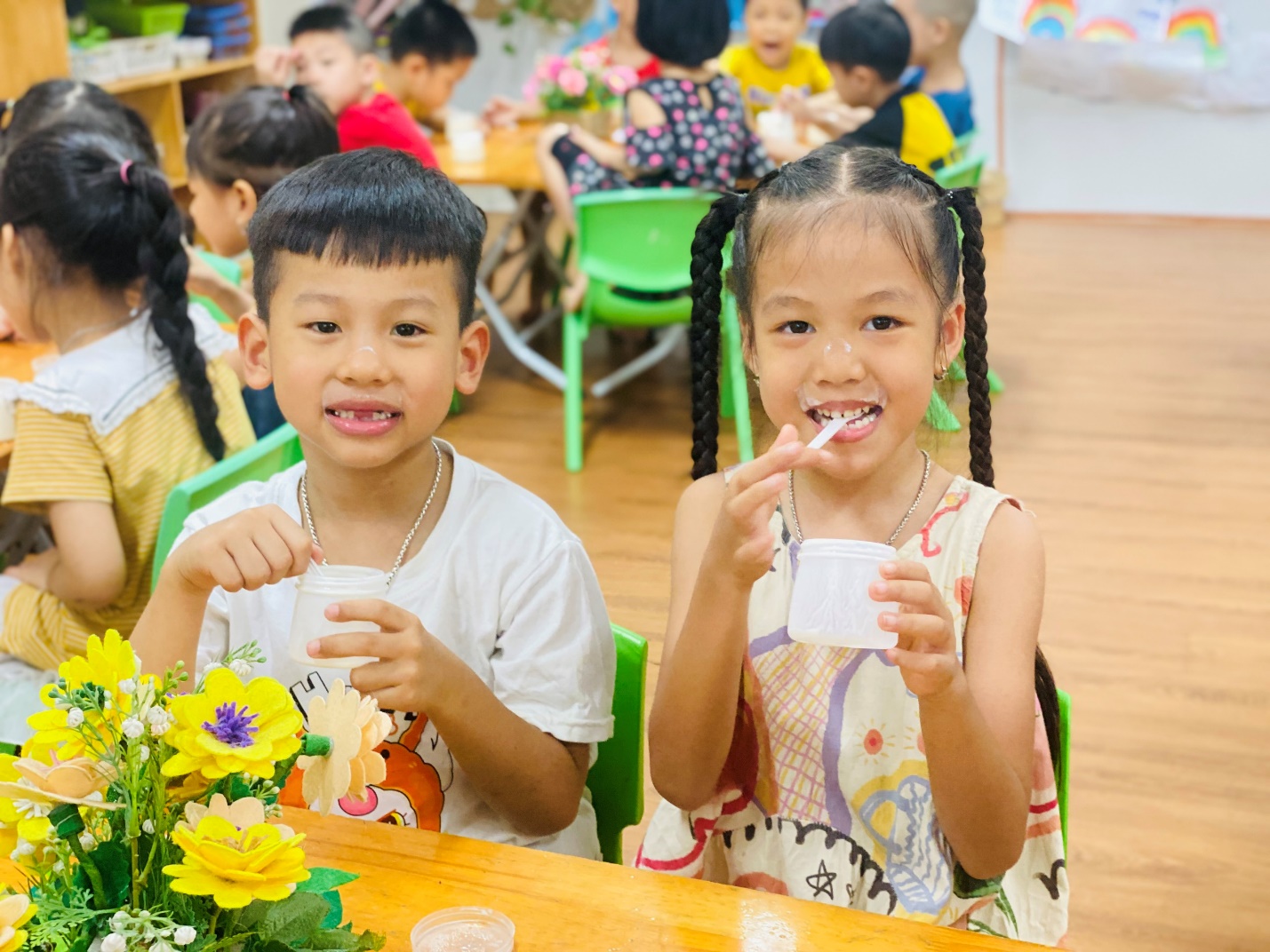 A child and child sitting at a table with a straw in their mouth
AI-generated content may be incorrect.
