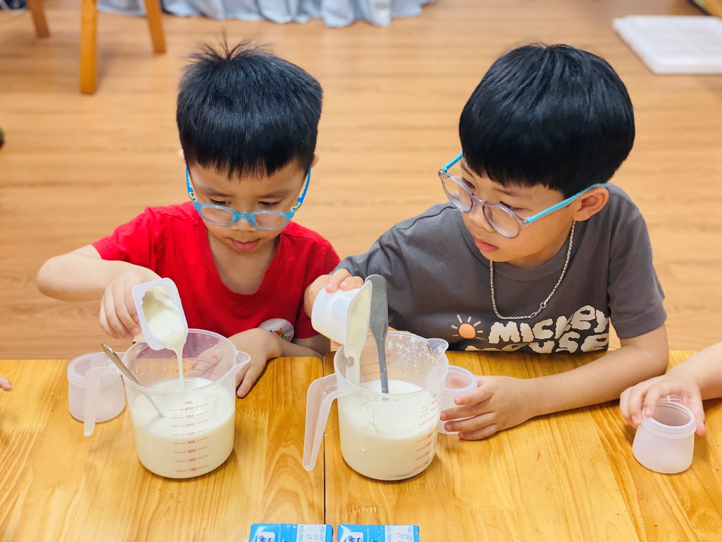 A group of boys pouring milk into a container
AI-generated content may be incorrect.