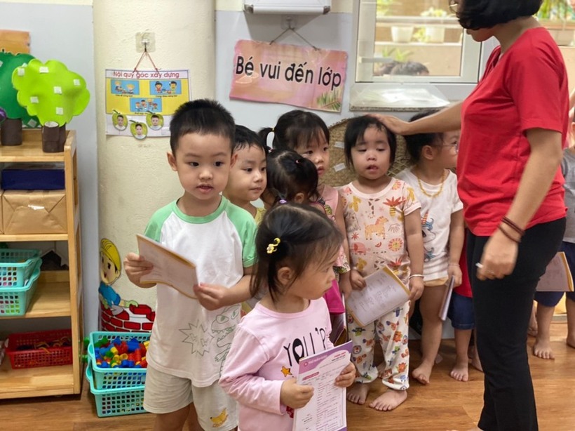 Các con xếp hàng chờ tới lượt khám dưới sự hướng dẫn của các cô